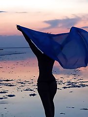 On sand seminude with light-color vase